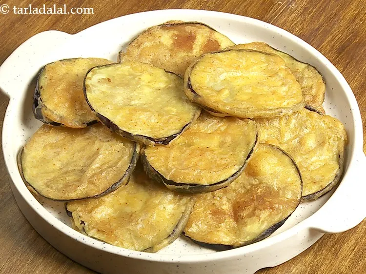 Step 19 – To assemble brinjal chaat, take 10 crispy brinjal slices and place them on a serving …