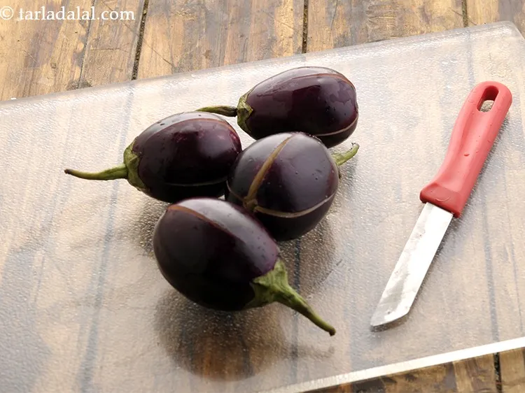 Step 11 – Similarly, make criss-cross cuts on the brinjals, taking care not to separate the segments