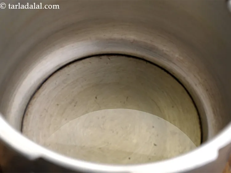 Step 25 – For making <strong>one pot dal rice</strong>, heat 2 tbsp of ghee in a pressure cooker.