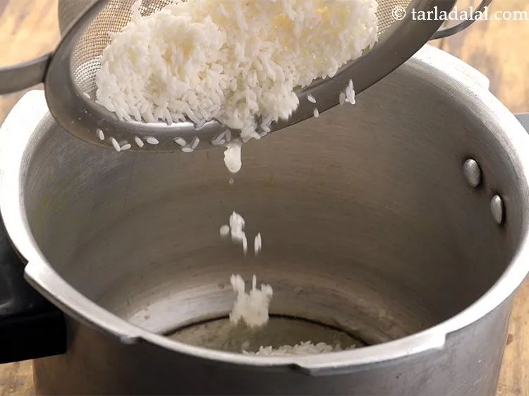 Step 27 – Drain the rice and add to the pressure cooker.