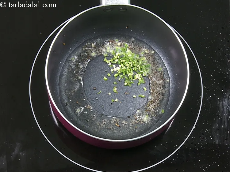 Step 11 – When the seeds crackle, add 1 tsp&nbsp;finely&nbsp;<a href="https://www.tarladalal.com/glossary-chopped-green-chilli-820i">chopped green chillies</a>.