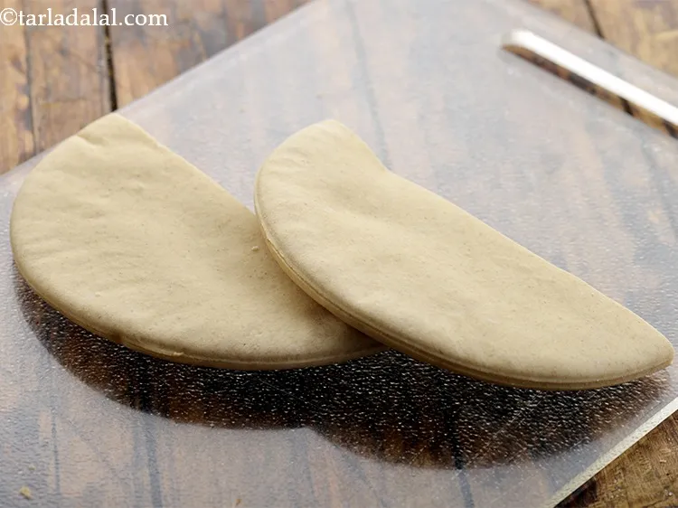 Step 29 – To make <strong>falafel in pita bread</strong>, cut a pita bread into two vertically.