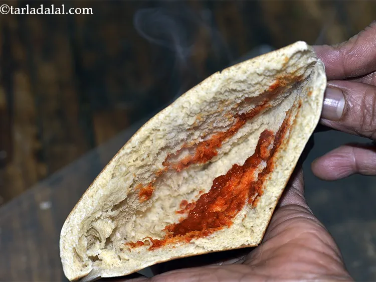 Step 33 – Take a pita bread halve, spread &frac12; tsp of garlic chutney evenly in it.