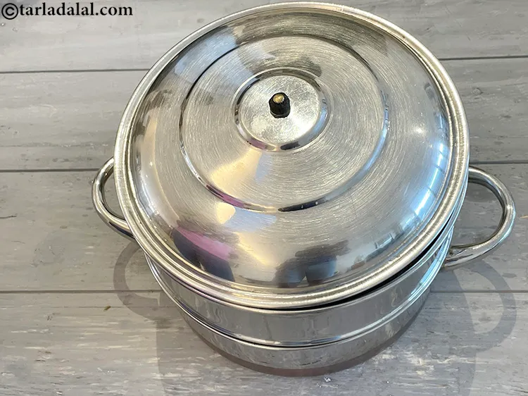 Step 21 – Steam in a steamer for 10 to 12 minutes or till the dhoklas are cooked.