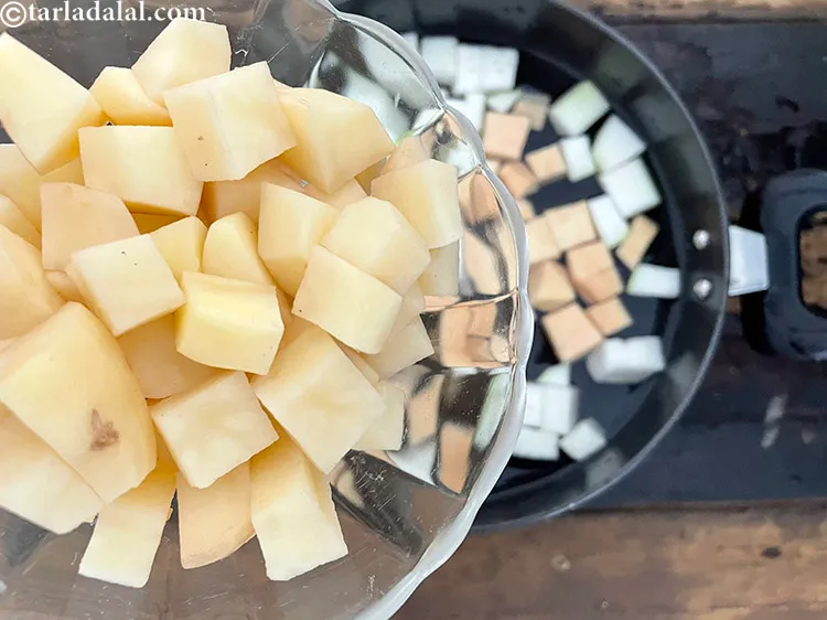 स्टेप 50 – १ कप छिले और <a href=""https://www.tarladalal.com/glossary-chopped-potatoes-hindi-787i"">कटे आलू</a> डालें।