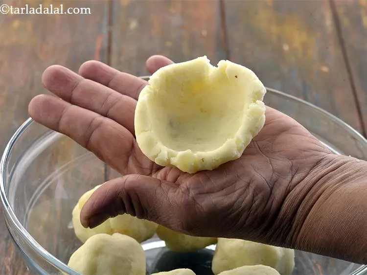 स्टेप 21 – अपनी हथेलियों के बीच में आलू के मिश्रण का एक …