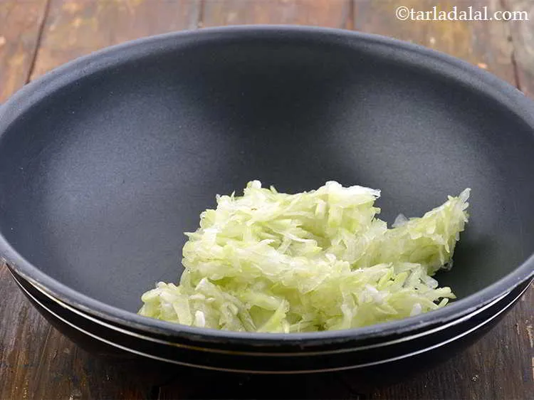 Step 5 – Take a non-stick kadhai and add the grated bottle gourd into it.