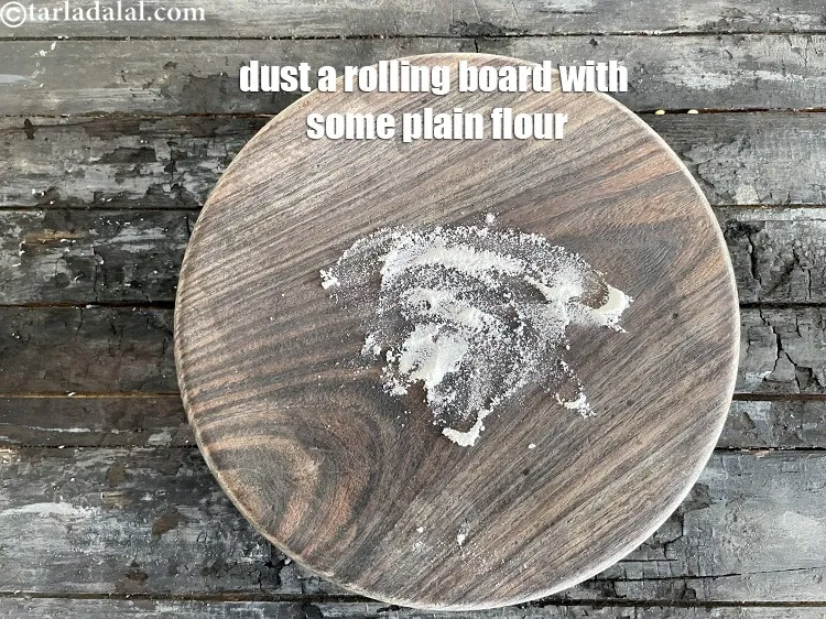 स्टेप 14 – एक रोलिंग बोर्ड पर थोड़ा सा मैदा छिड़कें।