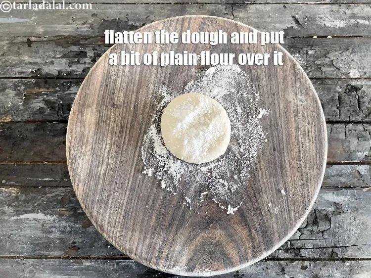 स्टेप 15 – आटे को चपटा करें और उसके ऊपर थोड़ा सा मैदा …