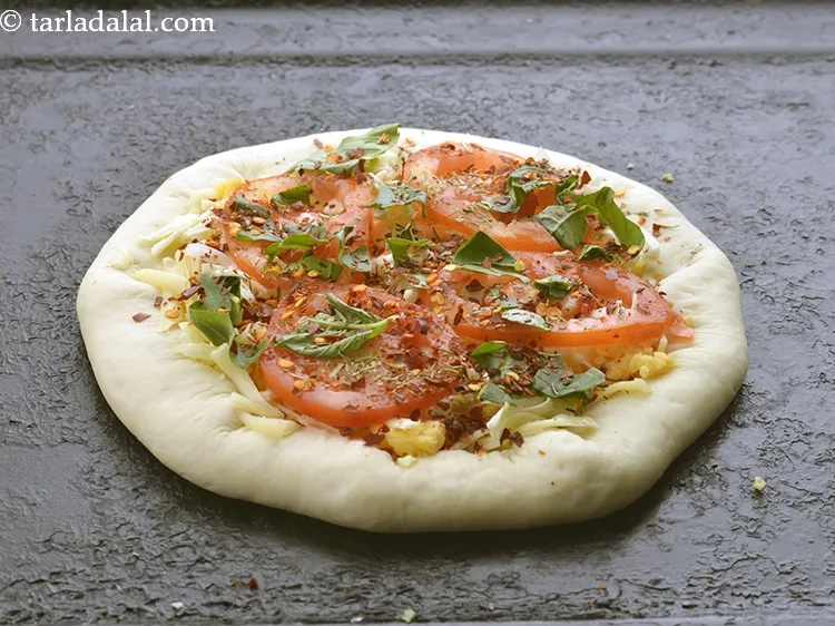 Step 23 – Also sprinkle 1 tsp of <a href="https://www.tarladalal.com/glossary-dry-red-chilli-flakes-paprika-338i">dry red chilli flakes (paprika)</a>&nbsp;evenly over it.