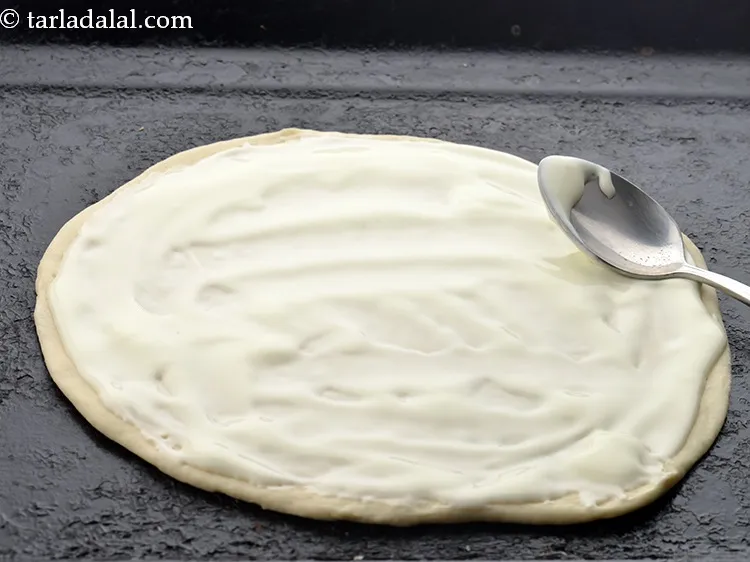 Step 15 – Spread 3 tbsp of <a href="https://www.tarladalal.com/glossary-cheese-spread-309i">cheese spread</a> evenly over it.