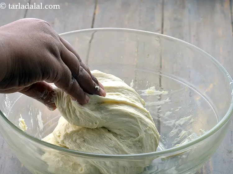 Step 16 – Scrape the sides of the bowl so as to loosen the dough. Pull the dough …