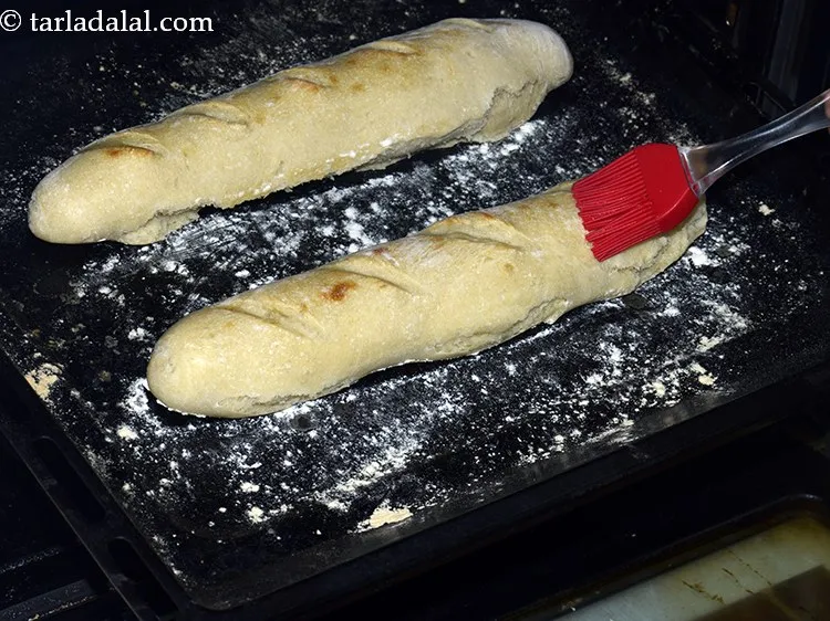 Step 28 – While the bread rolls are being baked, brush little water over each roll twice after …