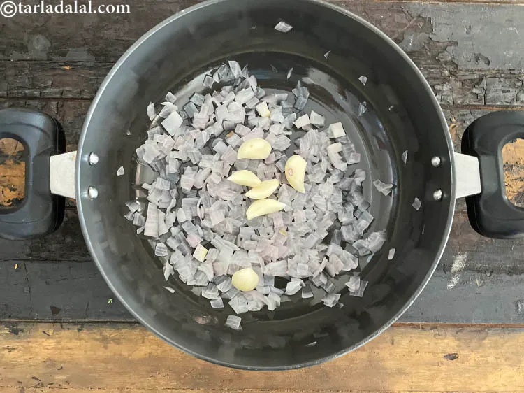 स्टेप 21 – ६ <a href=""https://www.tarladalal.com/glossary-garlic-cloves-hindi-1857i"">लहसुन</a> की कलियां डालें।