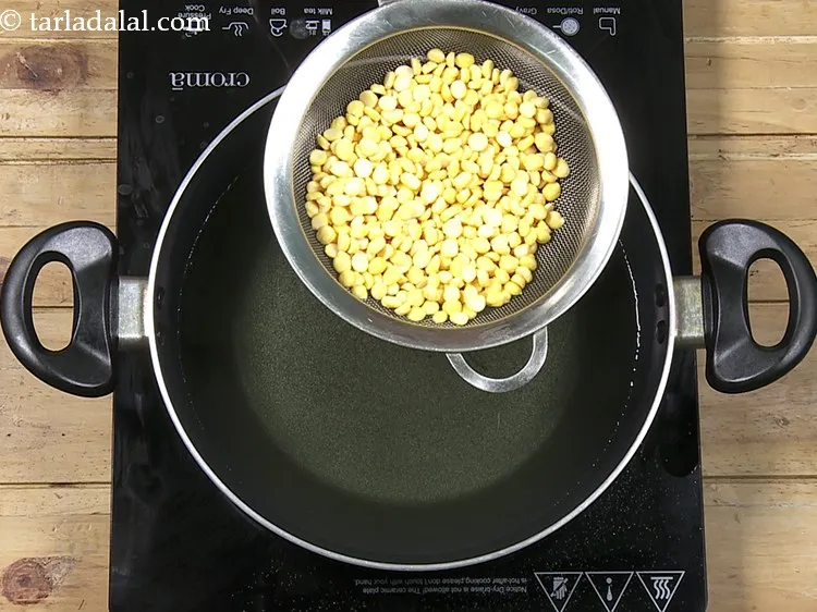 Step 25 – Take a strainer and put half the chana dal in it.