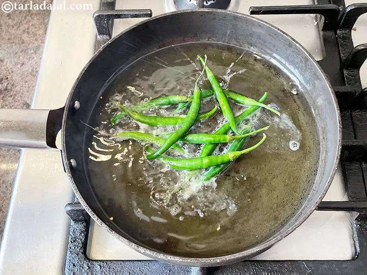 Step 4 – <meta charset="UTF-8" />Heat the oil in a deep non-stick pan and put the green chillies.