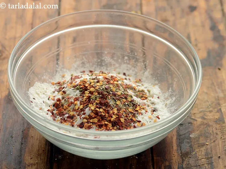 Step 5 – Add chilli flakes. Add chilli flakes and oregano to the batter will give our mozeraala …