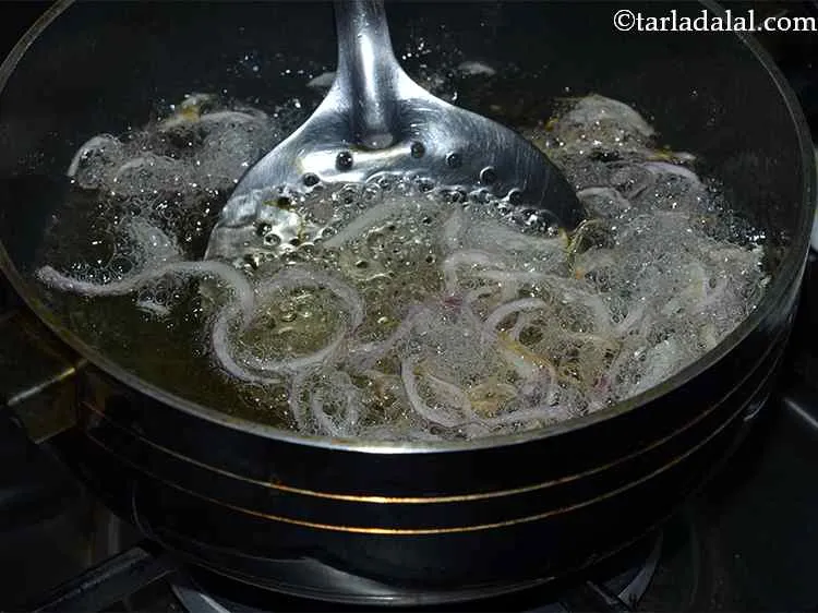 Step 32 – In the same hot oil, add the onions.&nbsp; Deep-fry on a slow flame till they …