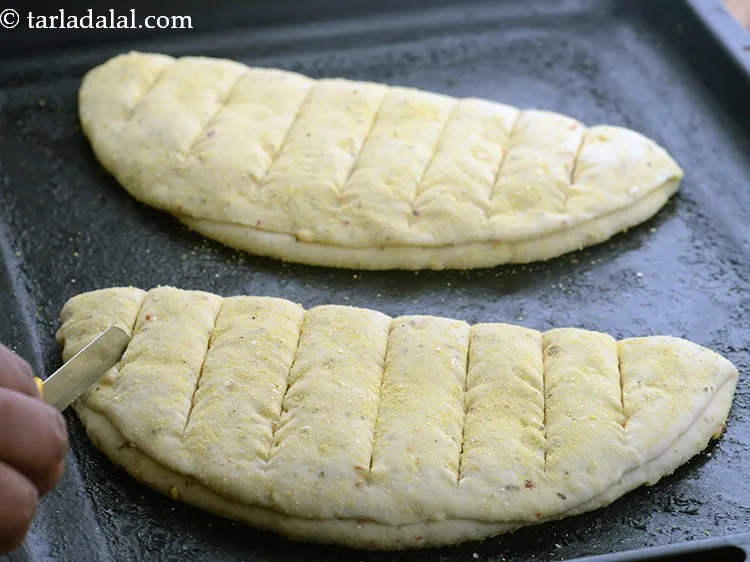 Step 37 – Slit vertically each garlic bread slightly at regular intervals using a sharp knife or a …