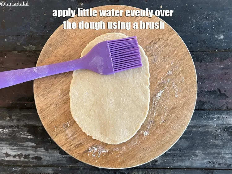 स्टेप 31 – ब्रश की सहायता से आटे पर समान रूप से थोड़ा …