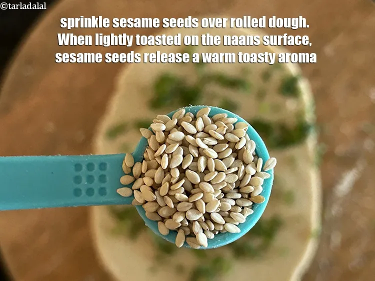 स्टेप 33 – बेले हुए आटे पर समान रूप से &nbsp;१/२ टी-स्पून&nbsp;तिल छिड़कें। …