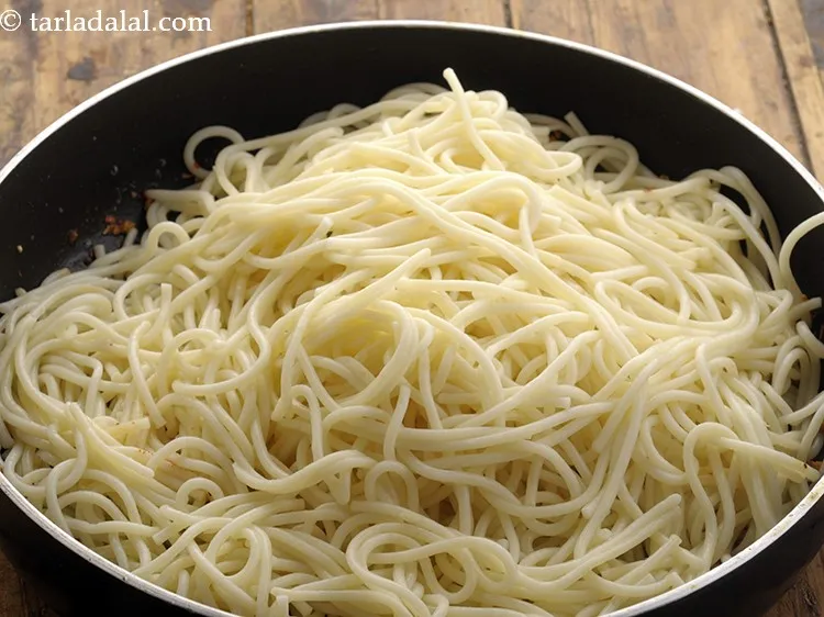 स्टेप 6 – आंच को बंद कर दें और उबली स्पैगेटी नूडल्स डालें।