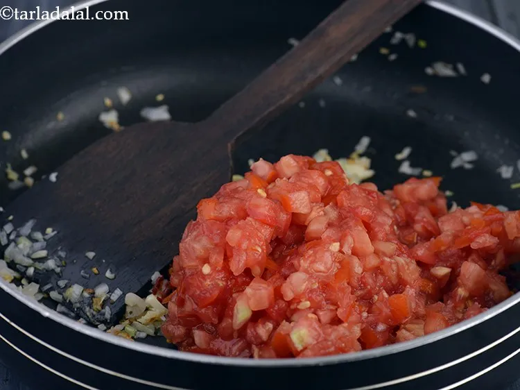 Step 27 – Then add 1 cup of finely chopped tomatoes. While chopping them, avoid the white part …
