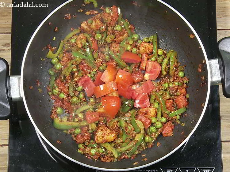 Step 24 – Add tomatoes, mix well and cook on a medium flame for 1 minute.