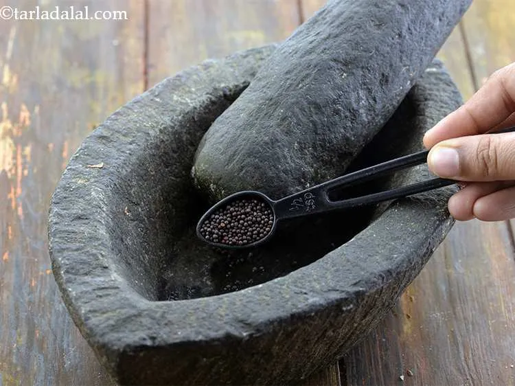 Step 2 – Take a <em>khal batta /sil batta</em> (mortar and pestle) and add the mustard seeds to …