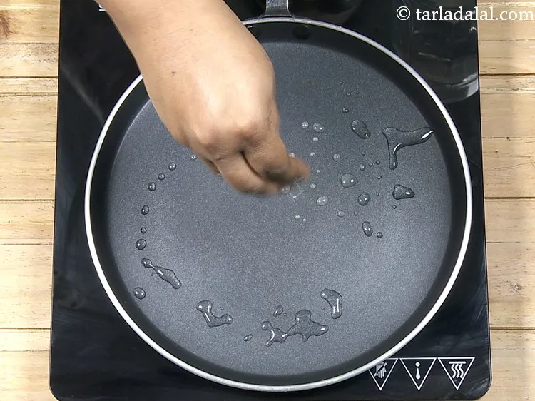Step 24 – Sprinkle a little water on the tava (griddle).