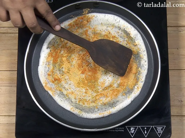 Step 31 – Spread it evenly using a flat ladle. It will stick to the ghee.&nbsp;