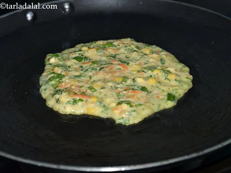 Step 30 – Pour a little batter on a greased tava (griddle). Spread it evenly to make a …