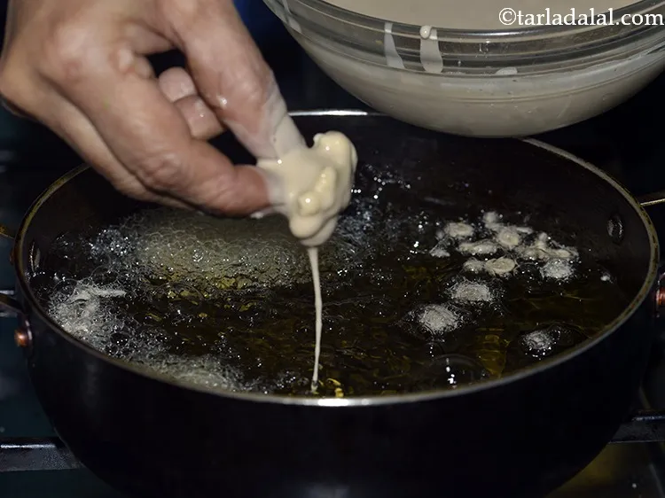 Step 20 – Dip a marinated cauliflower floret in the prepared batter.
