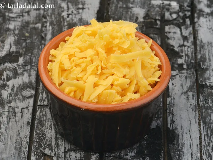 Step 18 – Sprinkle 1/4 cup of grated yellow&nbsp;<a href="https://www.tarladalal.com/glossary-cheddar-cheese-1172i">cheddar cheese</a>.
