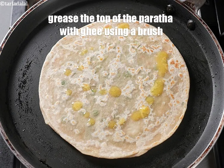 Step 43 – Grease the top of the paratha with ghee using a brush.