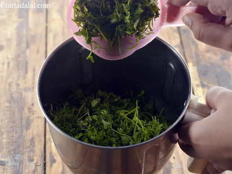 Step 8 – In a mixer jar, add the coriander leaves.