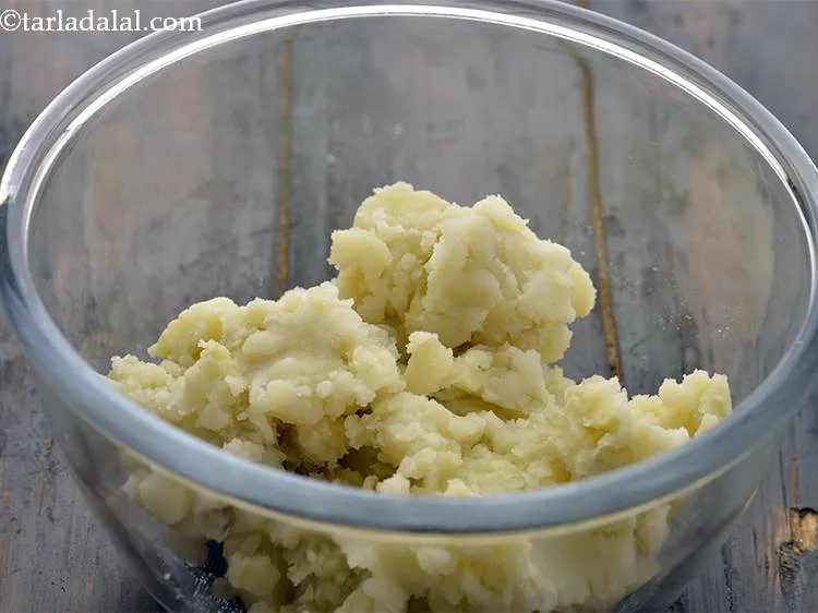 स्टेप 12 – आलू मैशर की मदद से आलू को मैश करें और …