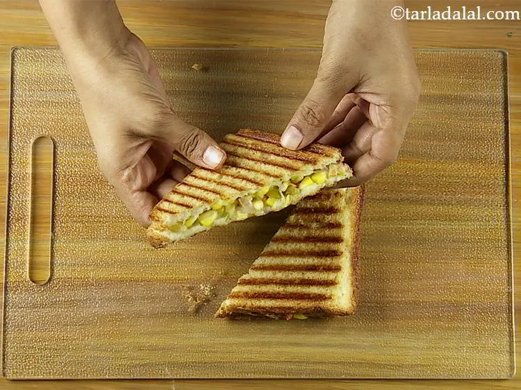 Step 19 – Cut the <strong>grilled corn and capsicum sandwich</strong> diagonally into 2 equal pieces.