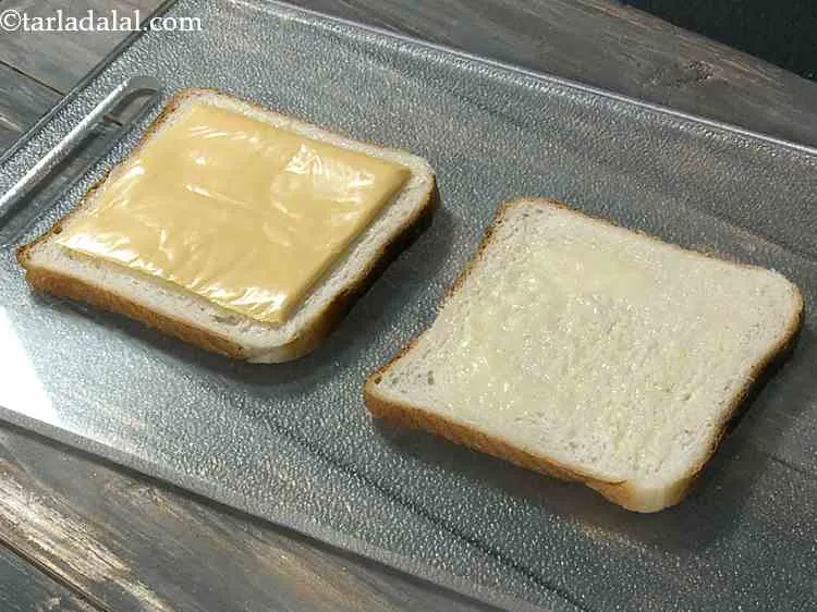 Step 4 – Place a cheese slice on one buttered bread slice. We have use processed cheese but …