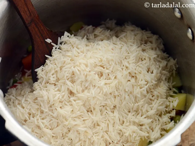 Step 17 – Add soaked and drained rice. You can even prepare masala bhaat using leftover rice.
