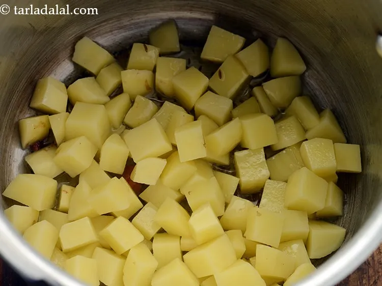 Step 10 – Add potatoes. Jains can skip adding potatoes to prepare Gujarati Masala Bhaat.
