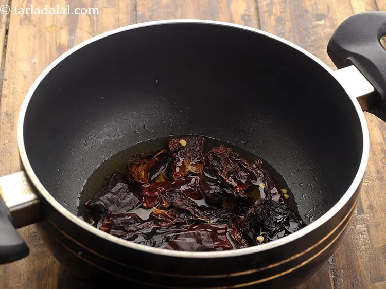 Step 3 – Add the broken red chillies and wait for a few seconds.