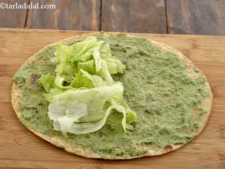 Step 39 – Arrange 1/4 cup of lettuce in a single row in the centre on the roti. …