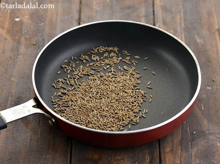 Step 24 – Heat a small broad non-stick pan, add the jeera to it and dry roast it …