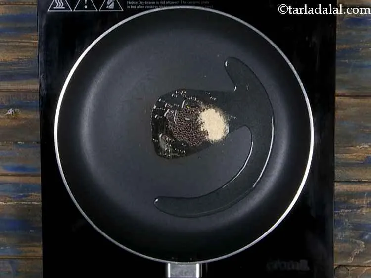 Step 10 – When the seeds crackle, add the asafoetida.