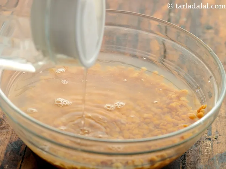 Step 3 – Transfer to a bowl, add water and soak arhar dal for half an hour.