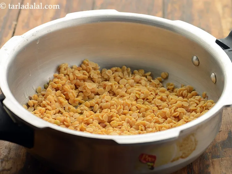 Step 4 – After 30 minutes, drain the toovar dal and transfer to a pressure cooker.