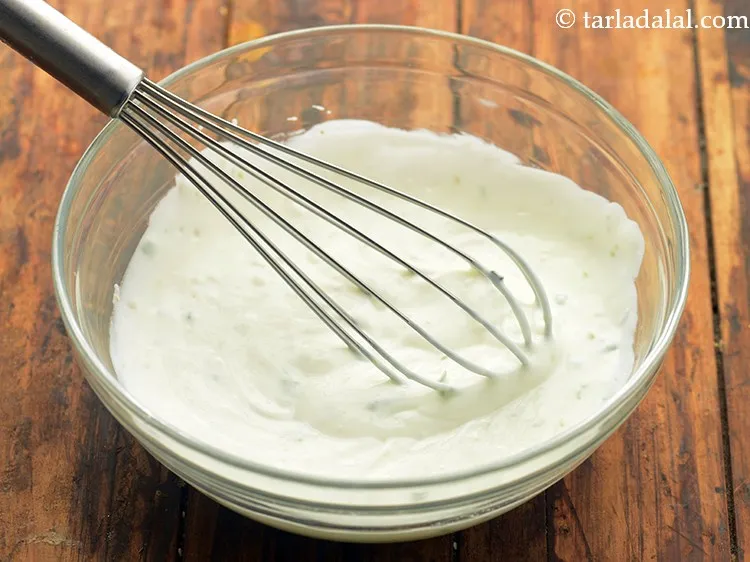 Step 11 – Mix well using a whisk to make <strong>low calorie cucumber raita</strong>.
