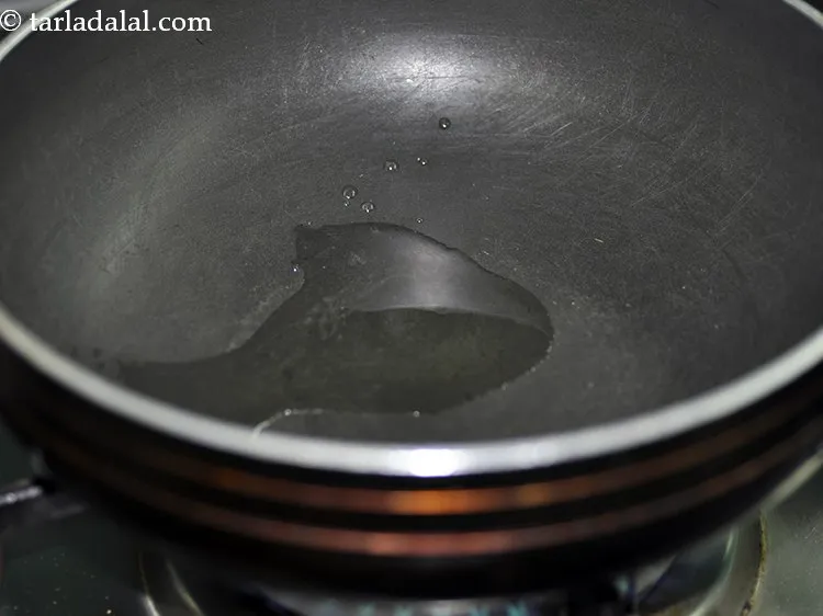 Step 21 – For tempering the kadhi, heat oil in a deep non-stick pan. Ghee can be used …