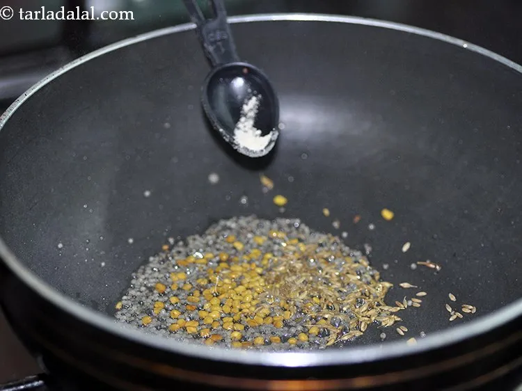 Step 24 – When they crackle, add asafoetida.